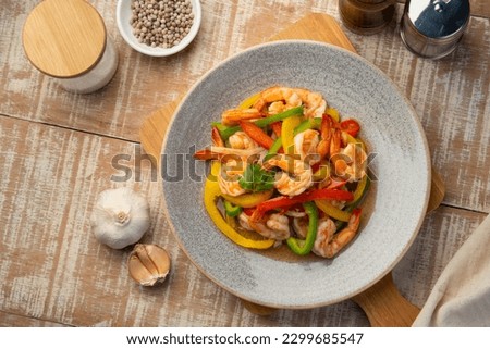 Stir Fried Sweet Peppers with shrimp,Stir fry shrimps and sliced red green and yellow bell pepper with sauce in a plate.healthy food.Top view