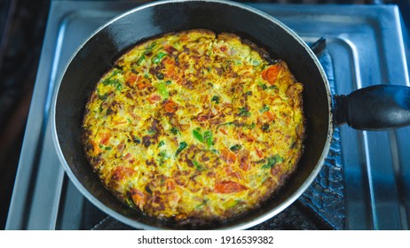 Stir Fried Veggie Omelet With Mix Vegetables In A Frying Pan On The Gas Stove. Indian Nepali Style  Masala Omelette