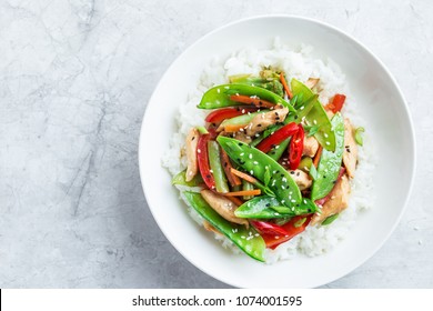 faire cuire du poulet frit et des légumes avec du riz dans un bol blanc, vue de dessus
