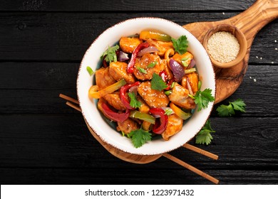 Stir Fry With Chicken, Vegetables, Soy Sauce And Sesame On Black Wooden Background. 