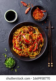 Stir Fry Noodles With Vegetables And Beef In Black Bowl. Slate Background. Top View.