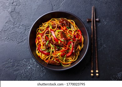 Stir Fry Noodles With Vegetables And Beef In Black Bowl. Slate Background. Top View.