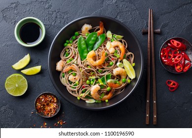 Stir Fry Noodles With Vegetables And Shrimps In Black Bowl. Slate Background. Top View.