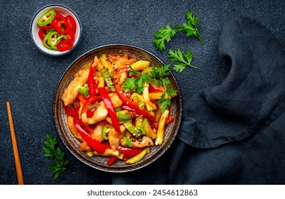 Stir fry turkey breast with red paprika and zucchini with sesame seeds, garlic, ginger and soy sauce in frying pan. Black table background, top view - Powered by Shutterstock