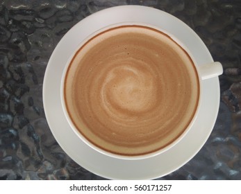 Stir Hot Cappuccino In White Cup On The Glass Table