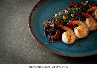 stir-fried black spaghetti with garlic and shrimps on plate - Powered by Shutterstock