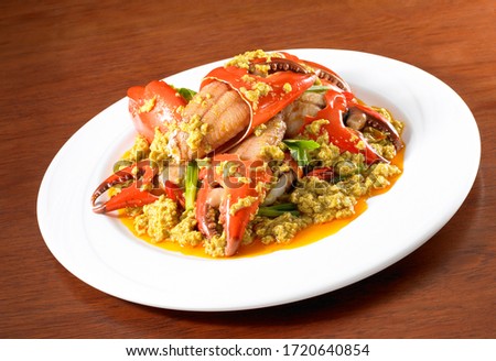 Stir-fried crab with curry powder is a popular food among Thai people on a wooden table.