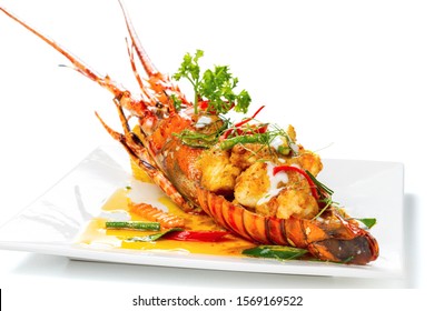 Stir-fried Lobster With Panang Curry Sauce (Thai Style) Topping With Coconut Milk On White Square Porcelain Plate, Isolated On White Background, Luxury Seafood Tail Side View. Selective Focus At Front