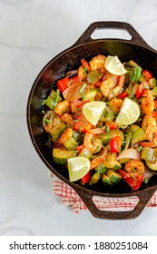 Stir-Fried Shrimp With Vegetables In A Cast Iron Wok Garnished With Garlic Chives And Lemon Top Down Vertical Photo