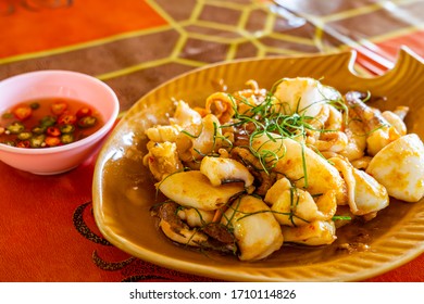 Stir-fried Squid With Boiled Salted Duck Egg Yolk In A Brown Dish On A Table.