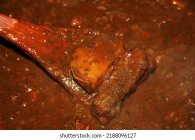 Stirring Curry Boiled In A Large Pot With A Wooden Spatula.
