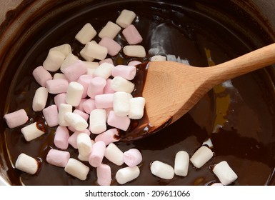 Stirring Pink And White Mini Marshmallows Into Melted Chocolate With A Wooden Spoon To Make Rocky Road