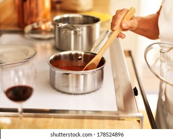 Stirring A Small Pot Of Spaghetti Sauce On The Stove