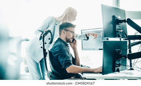 Stock broker business team trading online watching charts and data analyses on multiple computer screens in modern corporate work station office. - Powered by Shutterstock