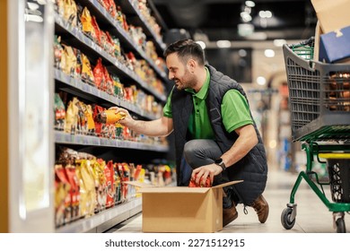 A stock clerk is arranging products on shelves at the supermarket. - Powered by Shutterstock