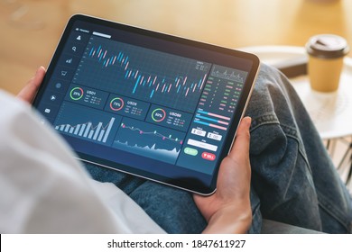 Stock exchange market concept, Hand trader touch on digital tablet with graphs analysis candle line on the table in house, diagrams on screen. - Powered by Shutterstock