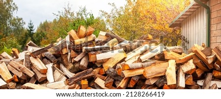 Stock of firewood for heating the house. The trees were cut down and split into firewood to be used as heating fuel in fireplaces and stoves, firewood background.