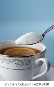 stock image of adding sugar to tea