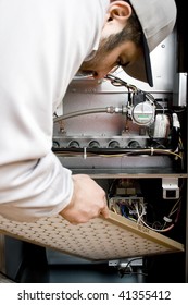 Stock Image Of HVAC Technician Replacing Filter On Furnace