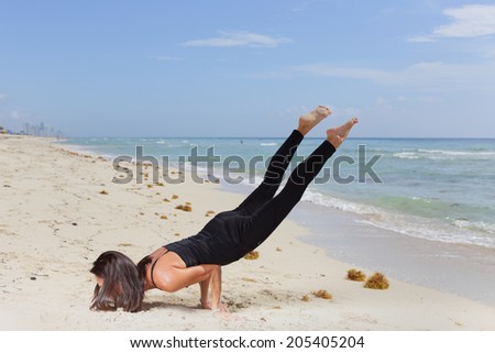 Stock image of woman balancing on her arms while raising her legs