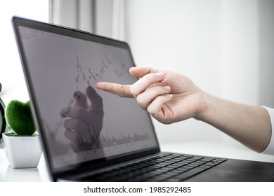 A Stock Investor Is Pointing To A Laptop Screen Running A Stock Chart Program To Read Stock Price Charts, Analyze Purchases. Cryptocurrency Stocks Are Popular With Both New And Old Investors.