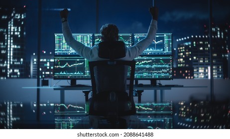 Stock Market Broker Working On A Computer With Multi-Monitor Workstation With Real-Time Investment, Commodities And Foreign Exchange Charts. Successful Businessman Punches Air For Winning A Trade.