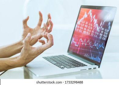 Stock Market Crash! Stressed Hand Gesture Of Investor Losing Everything While Working On A Laptop Computer. Money Loss On Investment And Economy Red Chart Falling. Close-up. 