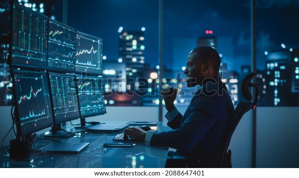 Stock Market Day Trader Working on Computer with\
Multi-Monitor Workstation with Real-Time Investmentment Charts.\
Successful African American Businessman Punches Air for Winning a\
Trade.