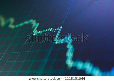 Stock market graph on the screen. Investing and concept gain and profits with faded candlestick charts. Candle stick graph chart. Stock market chart, graph on blue background.  