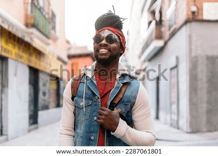 Stock photo of attractive and young african american boy looking at camera and walking in the street.
