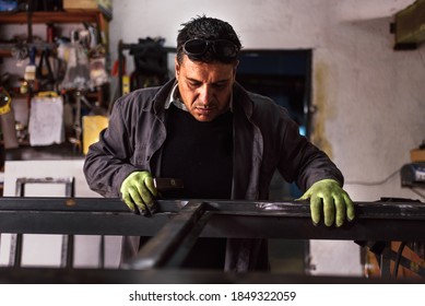 Stock photo of concentrated man wearing special gloves working in blacksmith shop. - Powered by Shutterstock