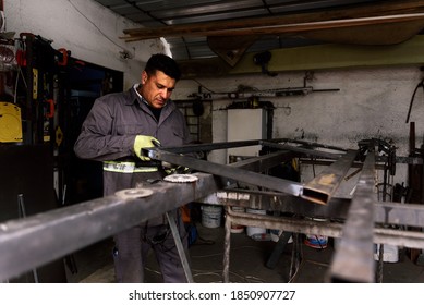 Stock photo of concentrated man wearing special gloves working in blacksmith shop. - Powered by Shutterstock