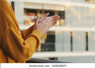 Stock photo of a girl's hands applauding from her balcony to support those fighting coronavirus