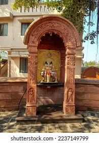 Stock photo of lord Dattatreya temple, beautiful idol of dattatreya with holy cow made from white marble. golden color metal sculpture behind the idol. brown color painted sculptural arch in front .