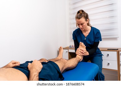 Stock photo of physiotherapist giving feet massage to patient lying in stretcher. - Powered by Shutterstock