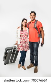 Stock Photo Of Smart Asian Or Indian Couple Traveler With Suitcase And Hike Bag Isolated Over White Background, Going Abroad Or Within Country, Perfect Shot For Tours And Travels Company