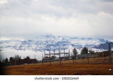 Stock Photo Of South Africa Drakensberg Mountain Hill Monks Cowl In Winter Snow With Power Station Electricity Cables With Storm Cloud And Mist 