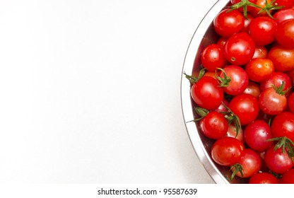 A Stock Photo Of A Stainless Steel Colander Of Fresh Cherry Tomatoes Sitting On A Textured Kitchen Counter Top