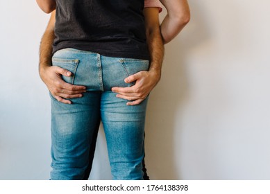 Stock photo of two caucasian homosexual men hugging each other. One of them is holding the others butt. They are unrecognizable.