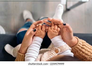 Stock photo of unrecognized mother sharing cute moment with her little baby in the living room.