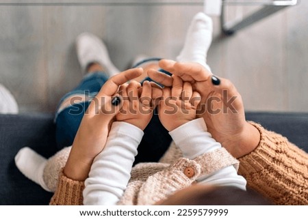 Stock photo of unrecognized mother sharing cute moment with her little baby in the living room.