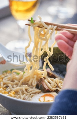 Stock photo of unrecognized person enjoying noodles soup in japanese restaurant.