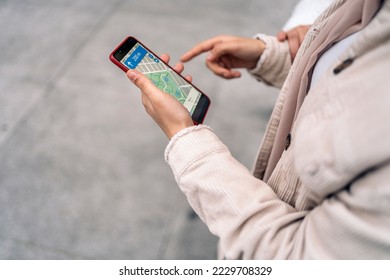 Stock photo of unrecognized woman looking at a map in her phone.