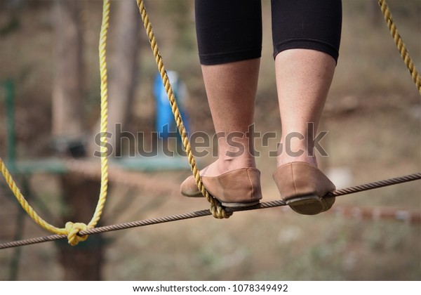 Stock photos,\
pictures and royalty-free images of Female foot is walking on a\
rope. She is doing outdoor adventure activities like rope balancing\
act with family on\
vacation