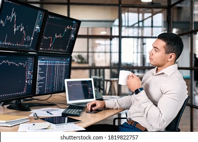 Stock trader in formalwear drinking coffee, looking at monitor, analyzing stat and dynamic on forex charts, working in office - Shutterstock ID 1819822757