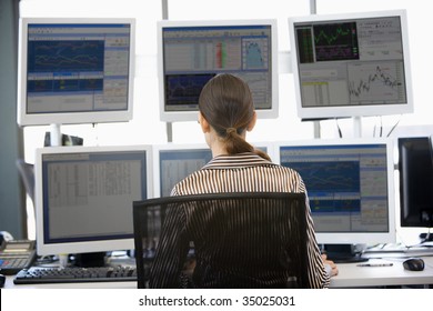 Stock Trader Looking At Multiple Monitors