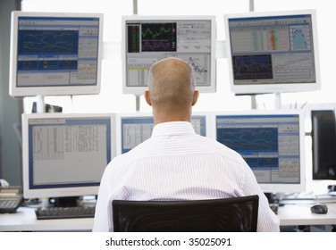 Stock Trader Looking At Multiple Monitors