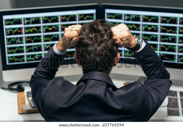 Stock\
trader tearing out his hair from despair, rear\
view