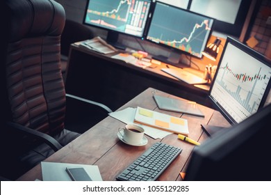 Stock trader workplace with financial market graphs on computer monitors - Powered by Shutterstock