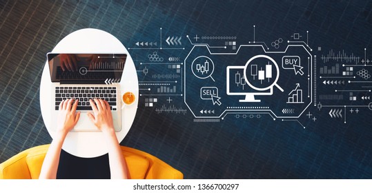 Stock trading concept with person using a laptop on a white table - Shutterstock ID 1366700297